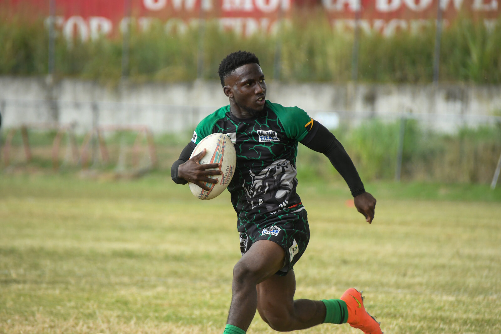 A rugby ball-carrier sprints clear in green and black
