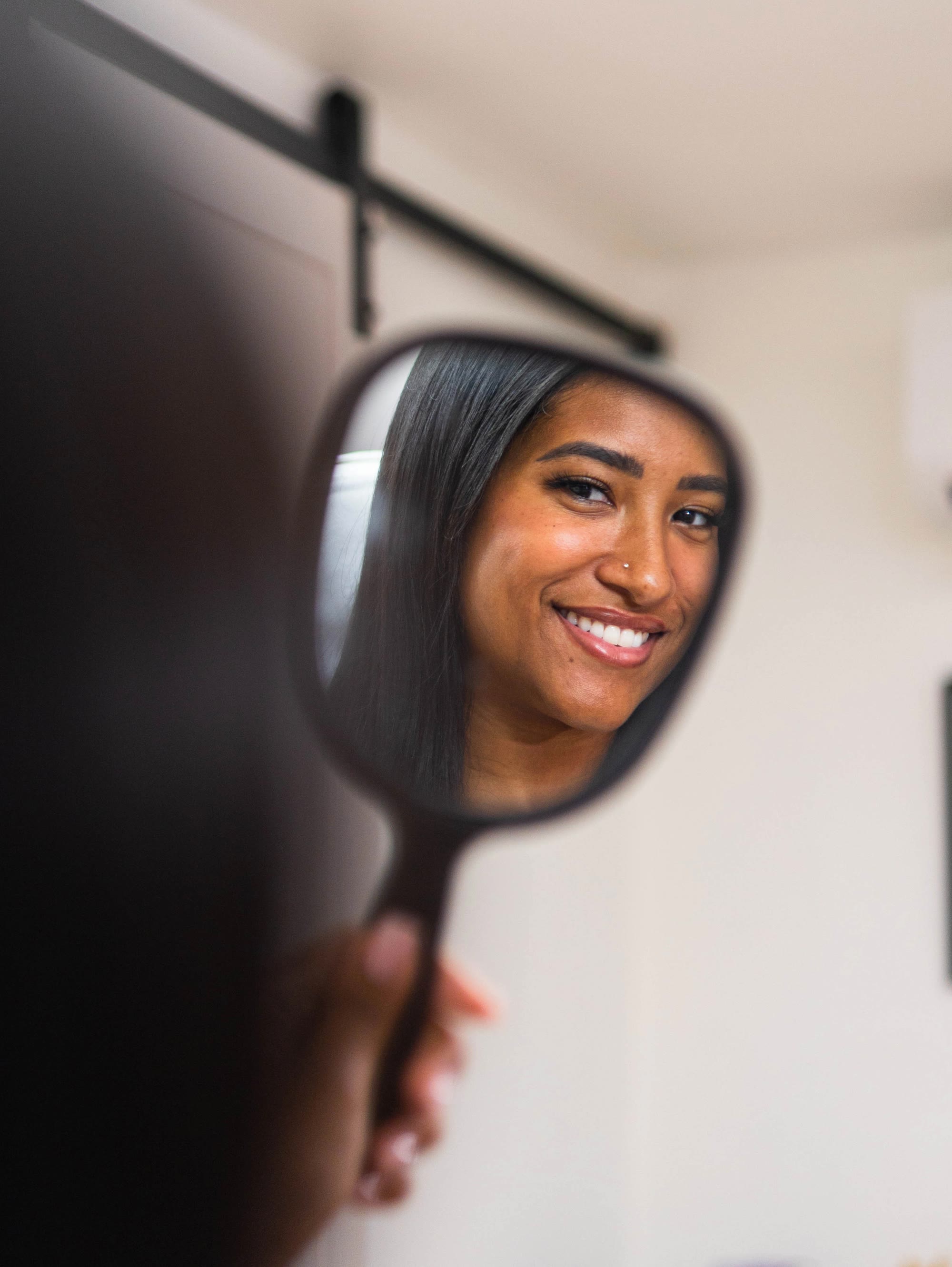 A patient seeing her result in the mirror at Avara Medical