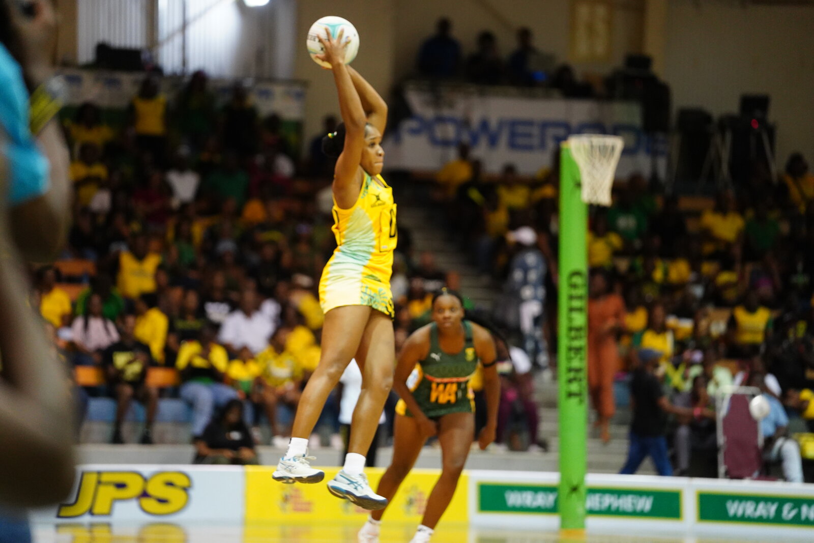 A Jamaica netballer takes the ball mid-air at the post