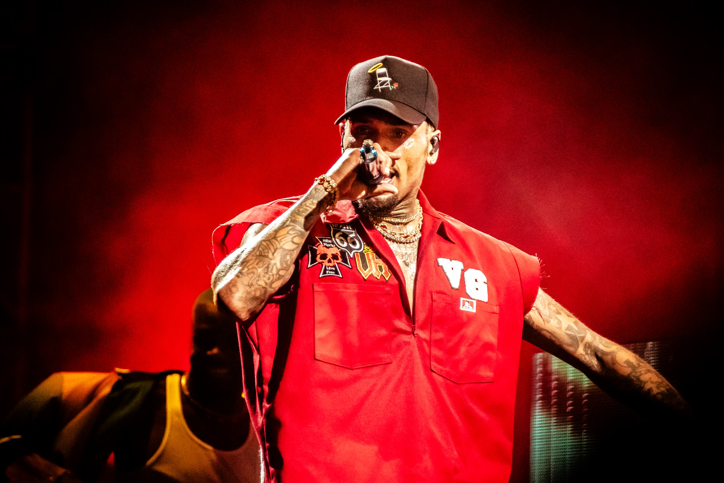 Breezy performs in a red jersey under red light