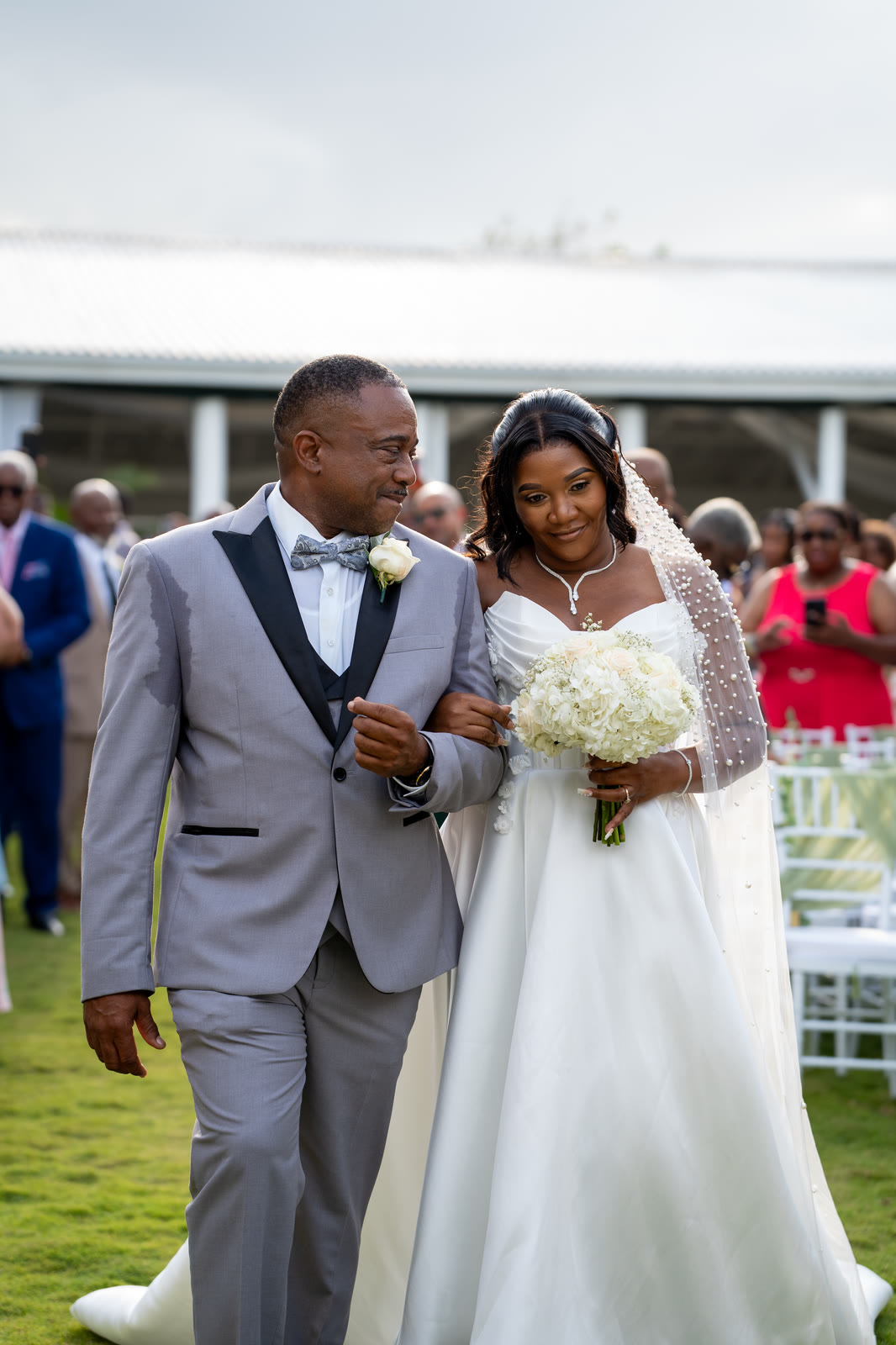 The bride and groom walk arm in arm past their guests