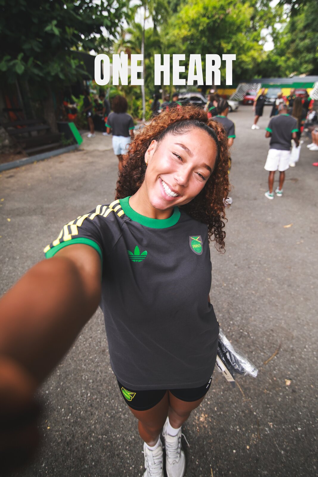 A Reggae Girl beams into the camera under One Heart type in the collab kit