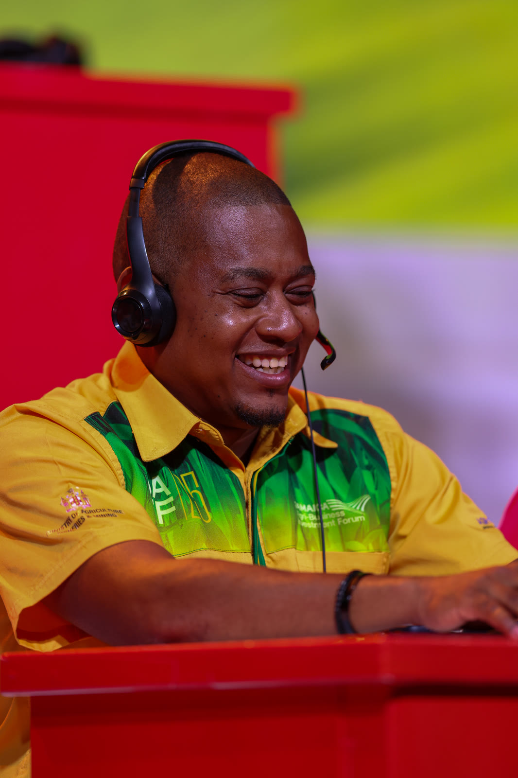 A phone bank operator in a headset smiles while taking calls