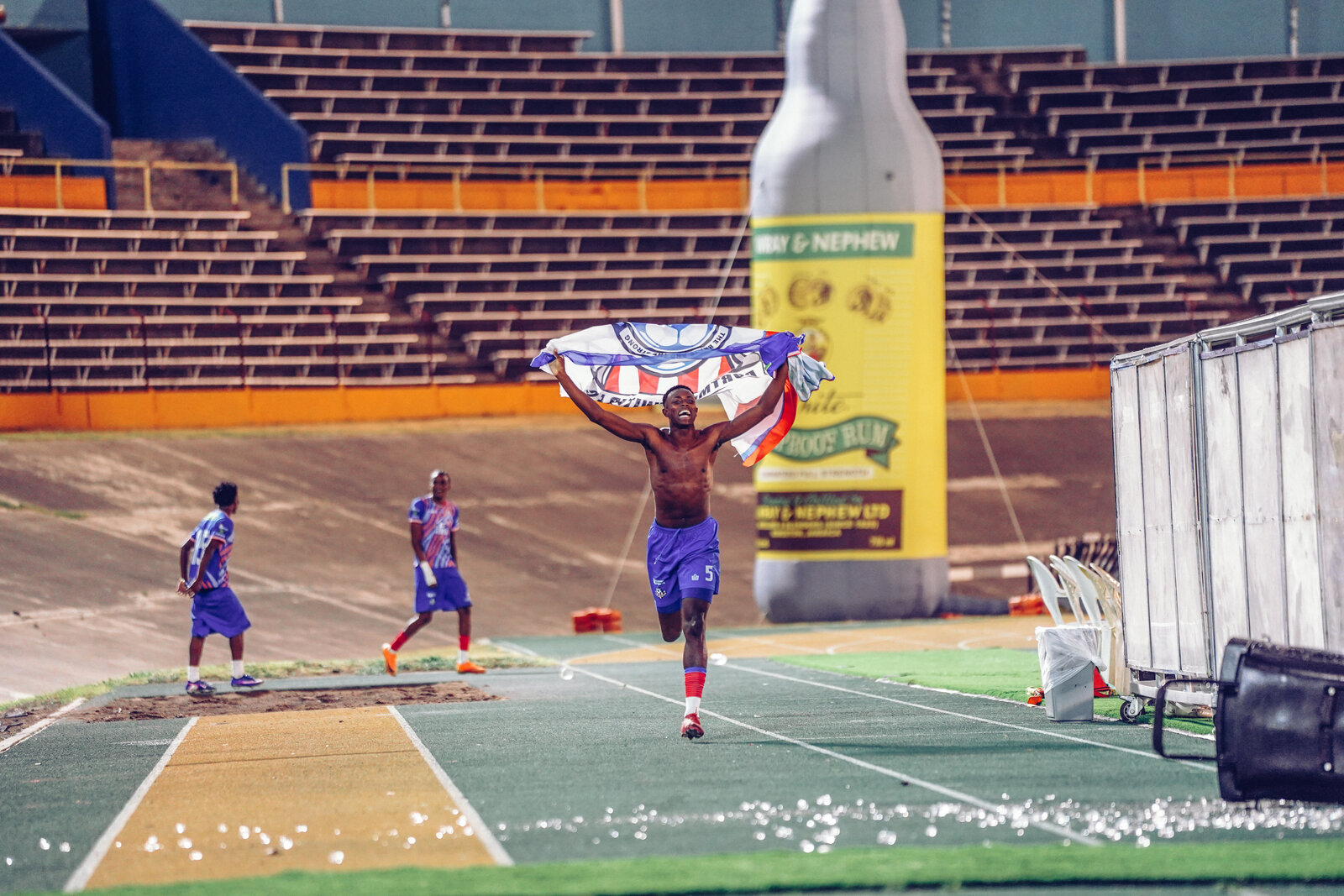 Players celebrate with the trophy on a Jamaica Premier League night