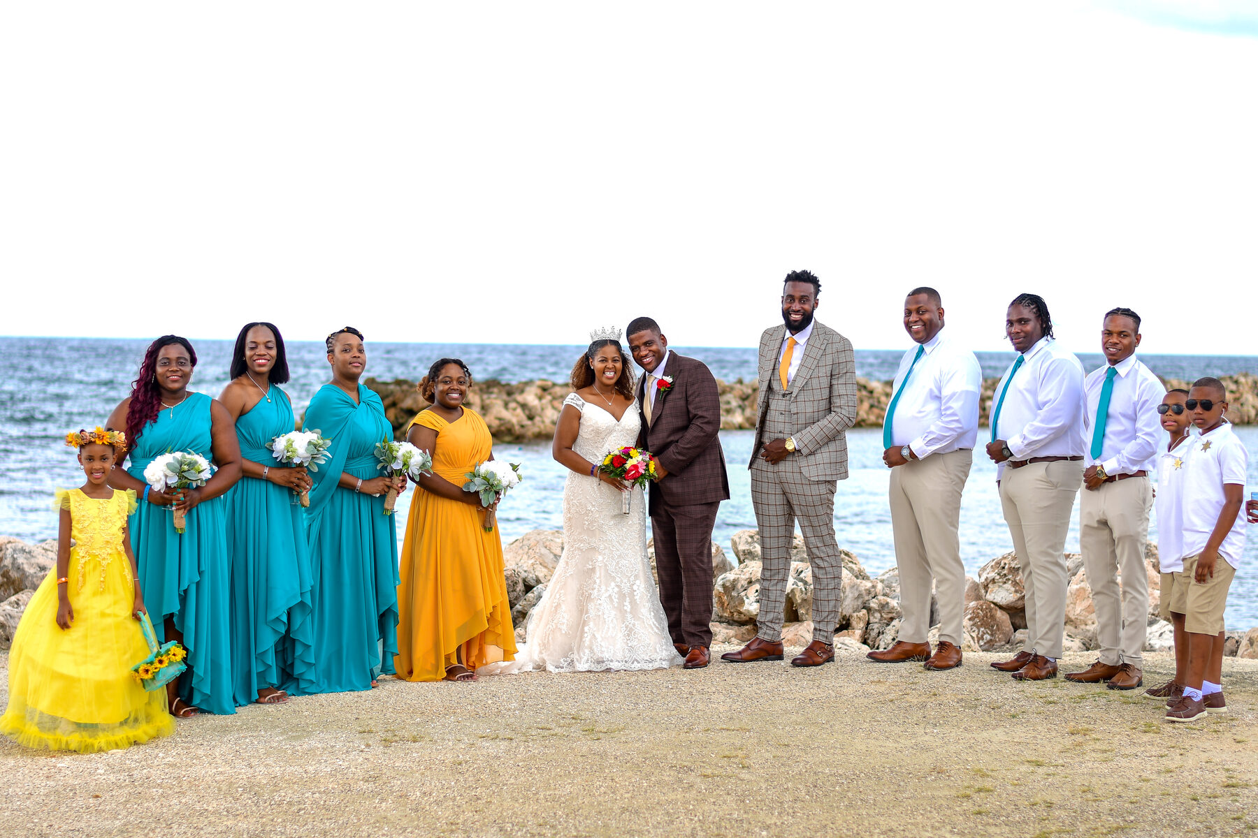 The wedding party in teal and yellow on the beach