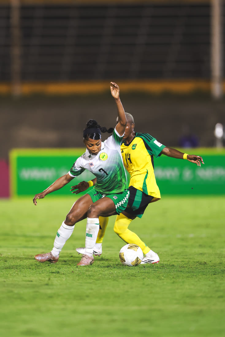 A Jamaica player battles a Guyana defender for the ball