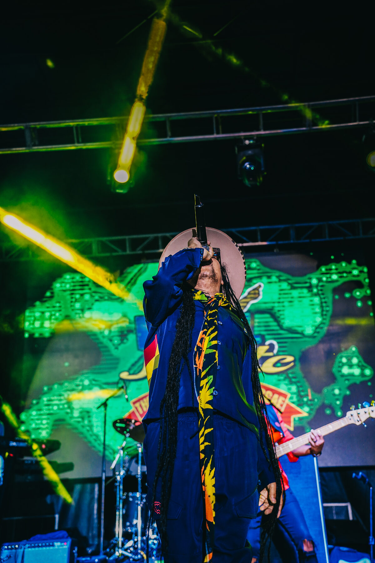 A band performs on a stage cut by green laser light