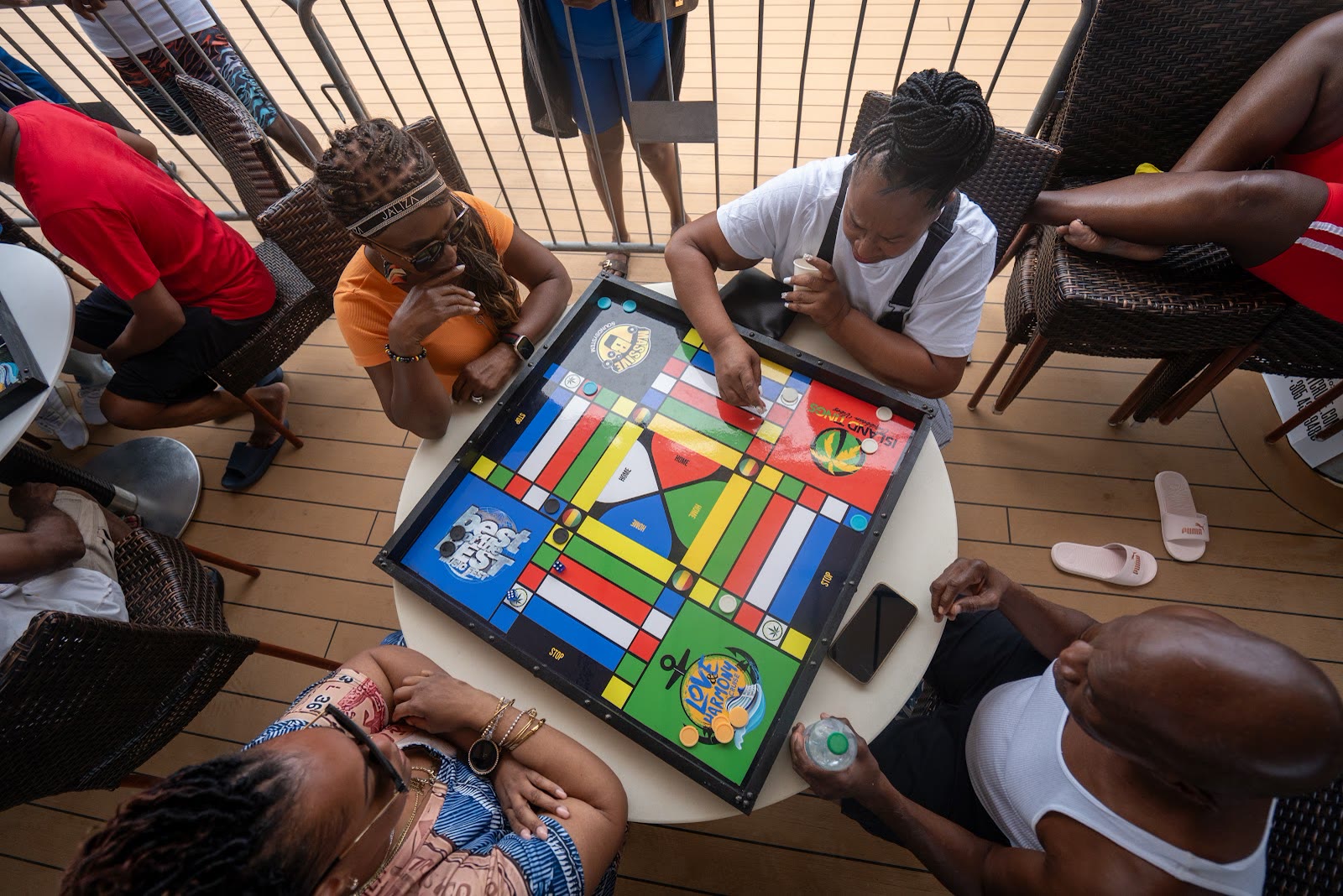 Guests gather around a ludo board on deck