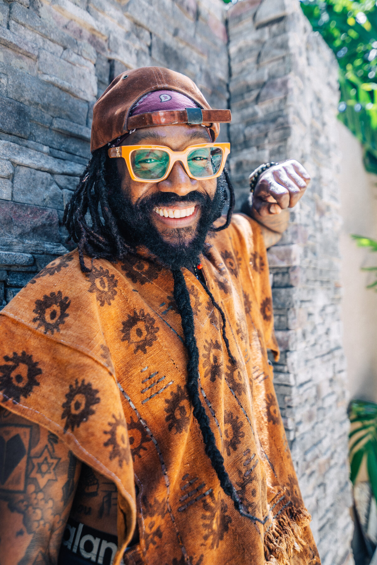 A creative portrait of a person in bold African print and patterned glasses