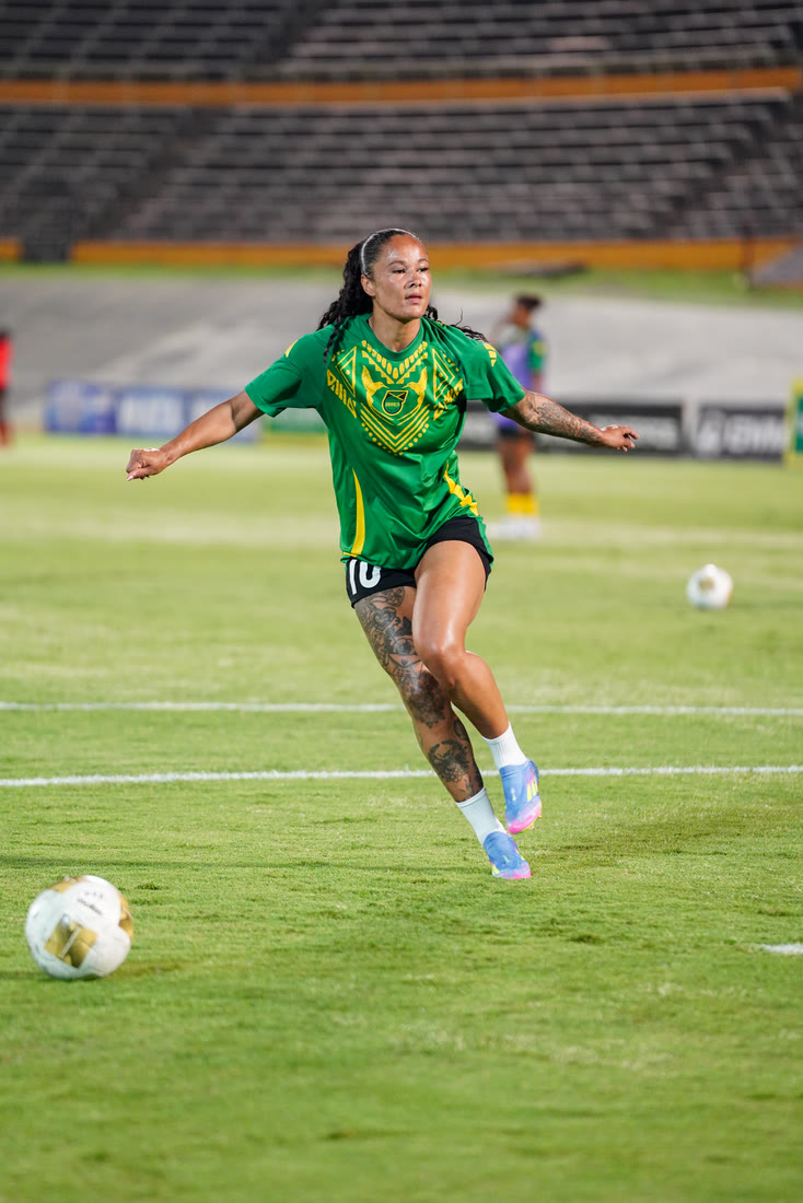 A player runs onto the ball in the warm-up under the lights
