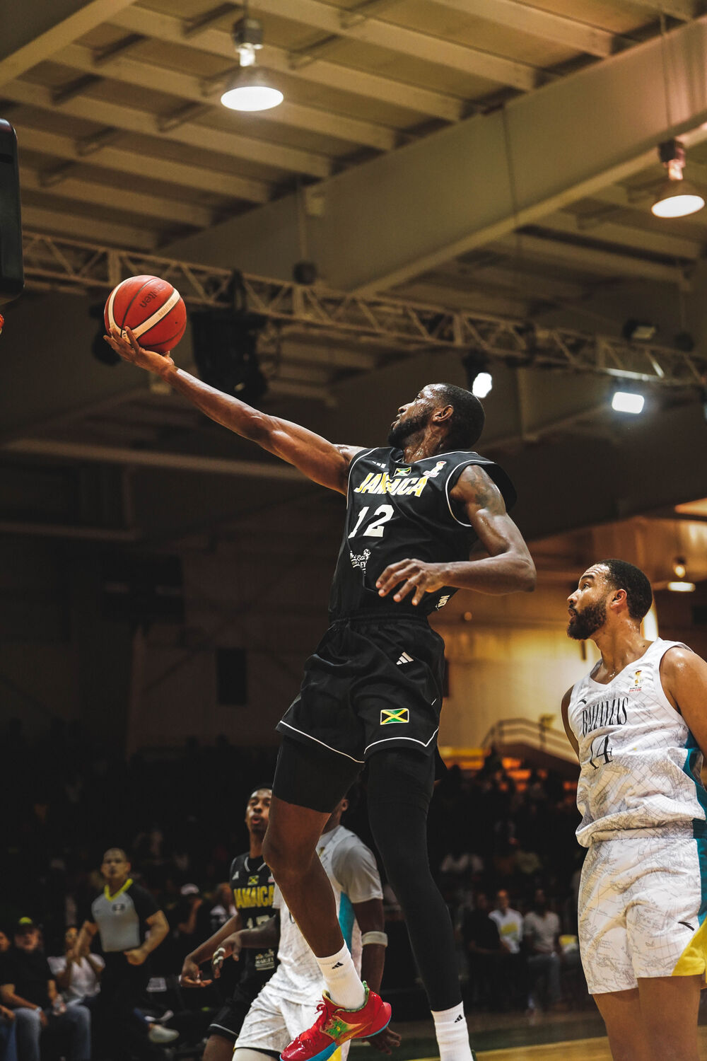 A basketball player explodes to the rim in a packed arena