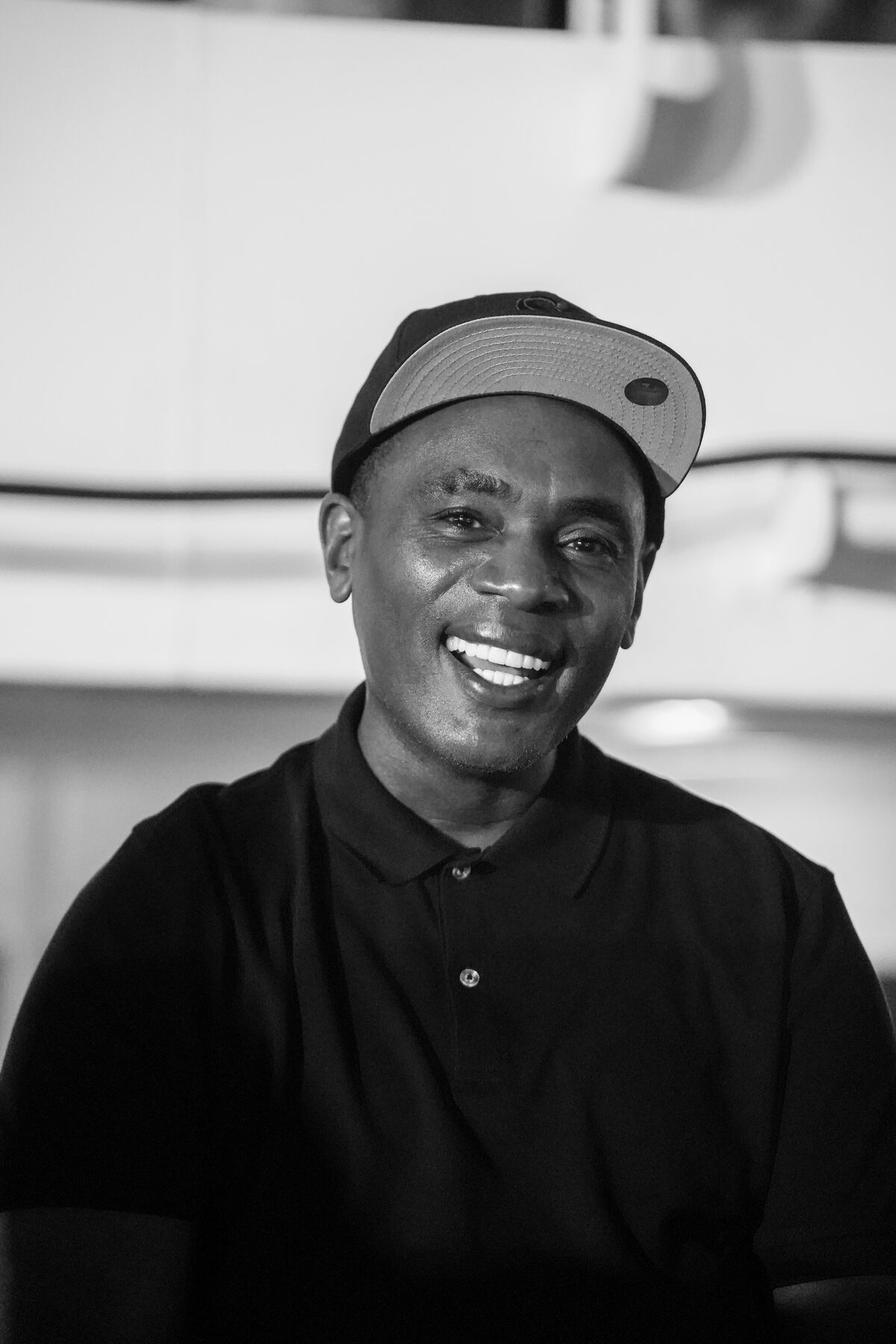 A black-and-white portrait of a dignified older man in a cap