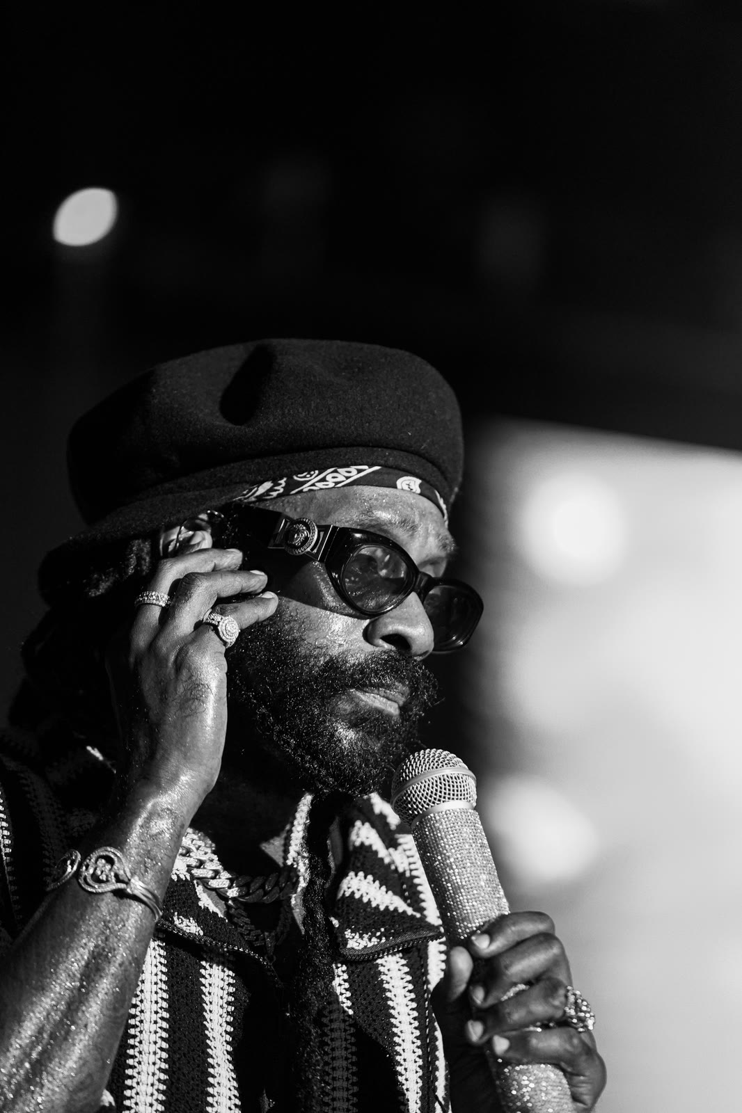 A black-and-white frame of Tarrus Riley with his hand to his ear