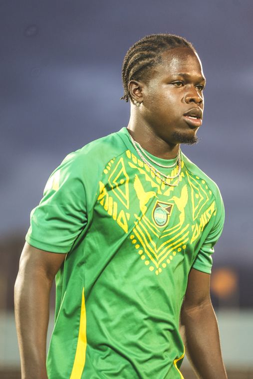 A Reggae Boyz player in the green training kit during the warm-up