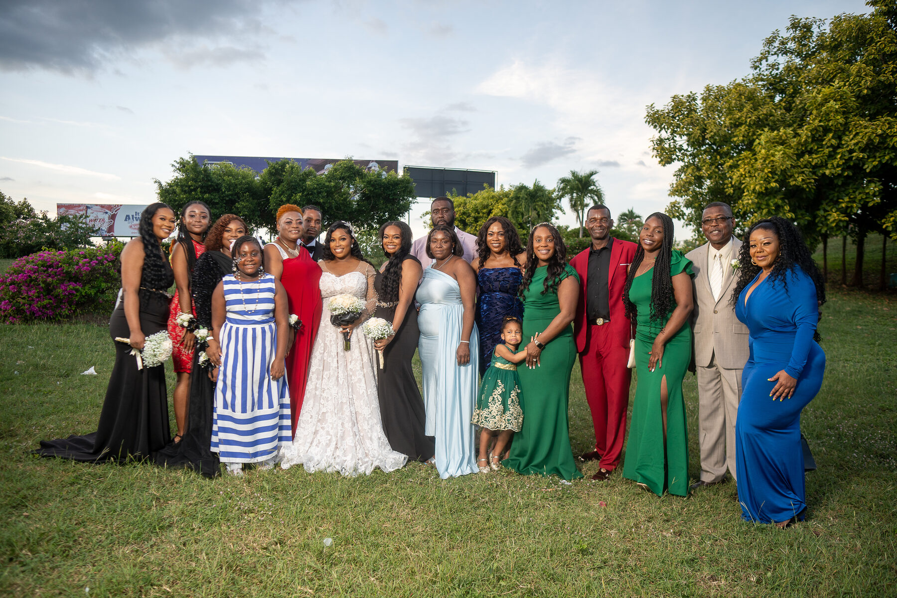 A large wedding party in colourful dresses on the lawn
