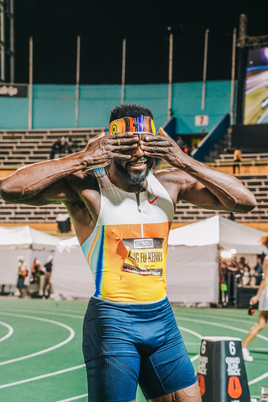 A sprinter throws heart hands on the track