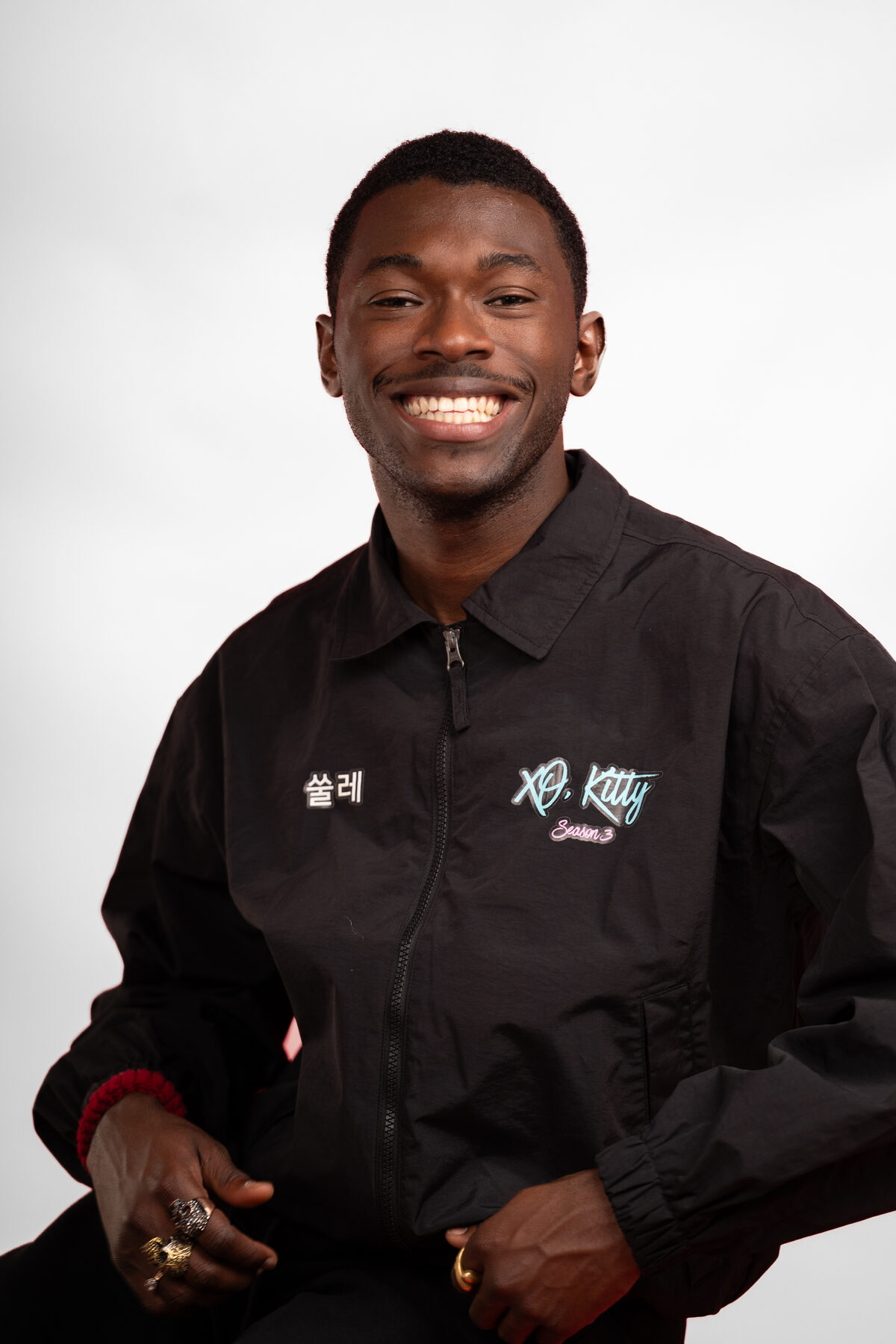 A clean professional headshot of a young man in a dark polo
