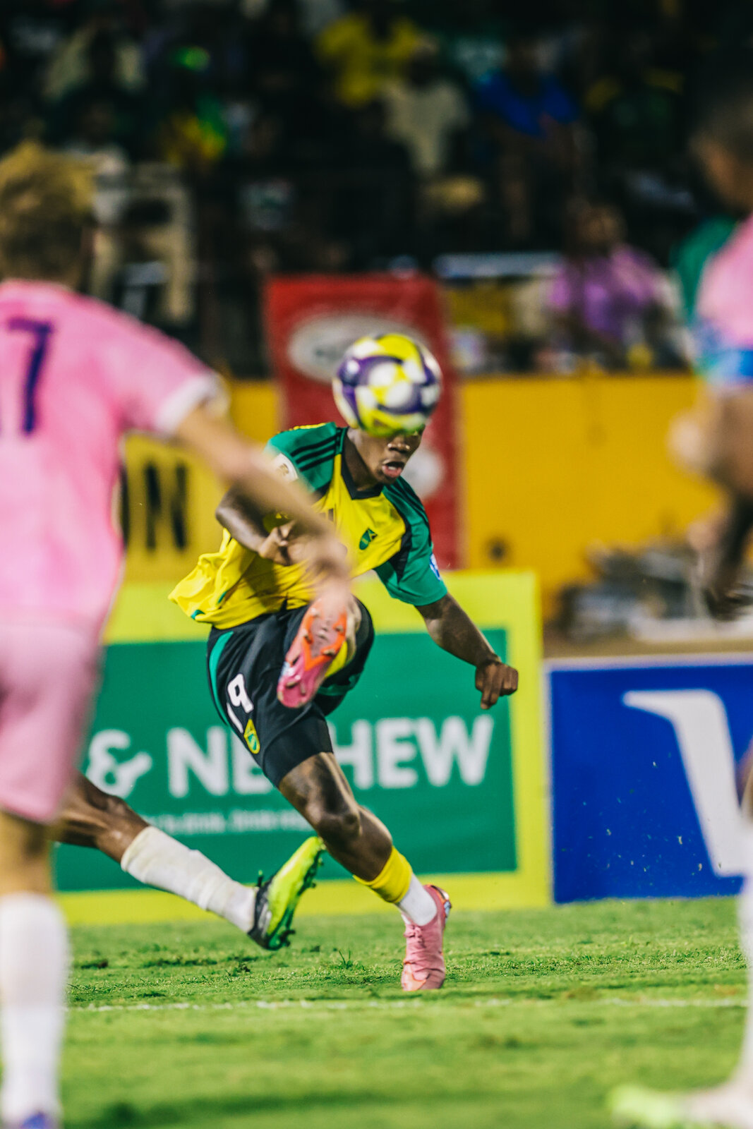 Whisper Richards strikes a volley for Jamaica against a pink-kitted side