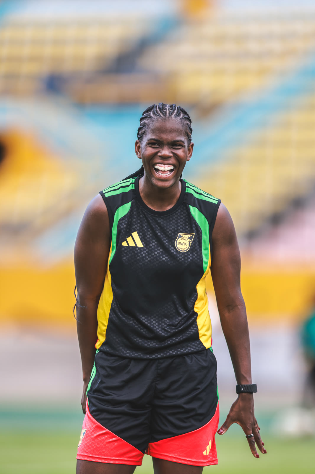 Bunny Shaw laughs at training in the black and green training top