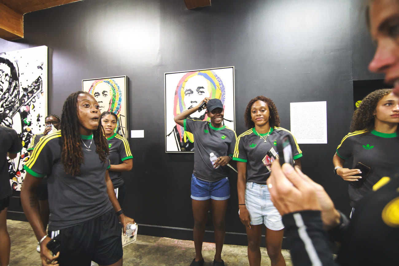 Players pose with a portrait of Bob Marley inside the museum