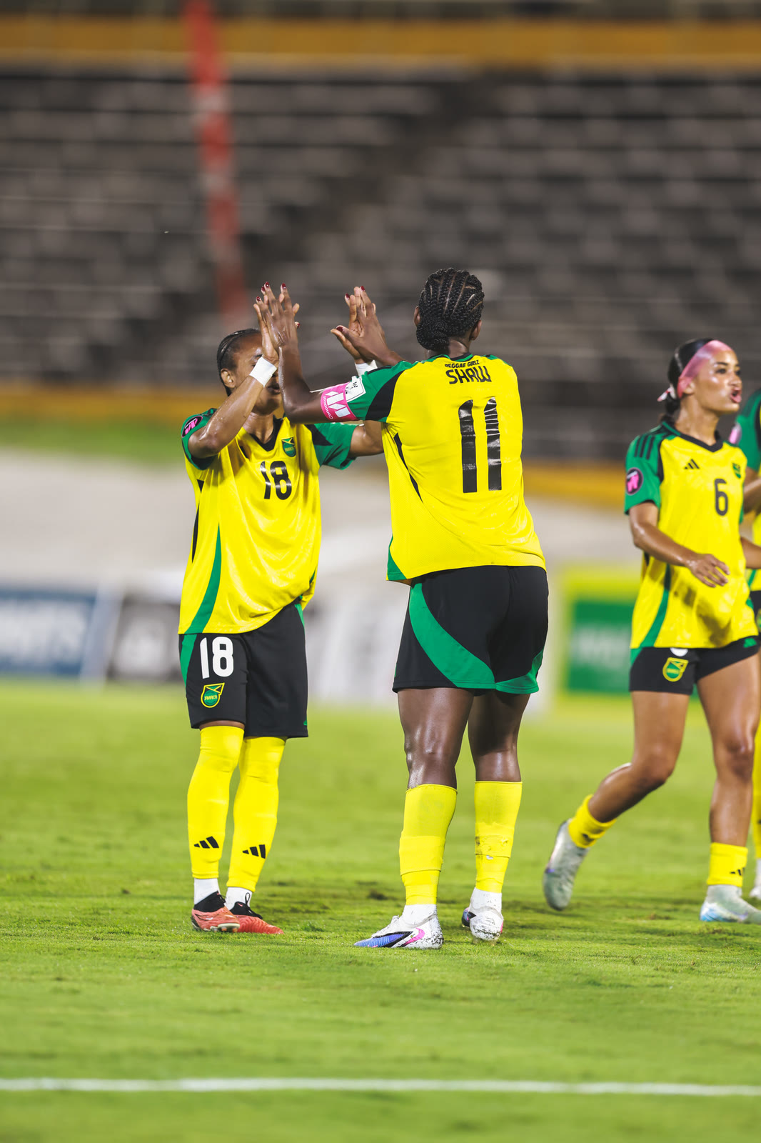 Numbers 18 and 11 high-five early in the qualifier against Guyana at the National Stadium