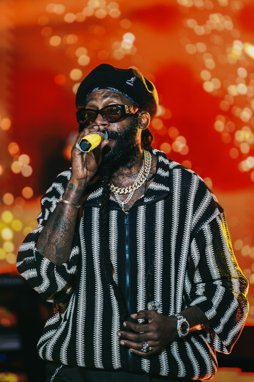 Tarrus Riley sings in front of an orange glow