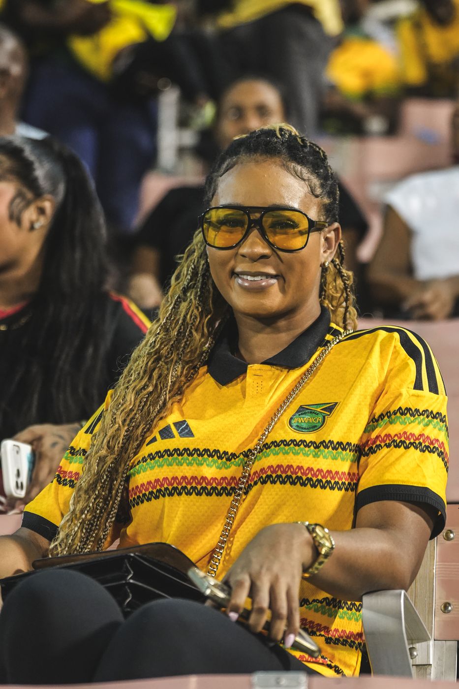 A supporter in the stands wearing the Jamaica jersey and yellow sunglasses
