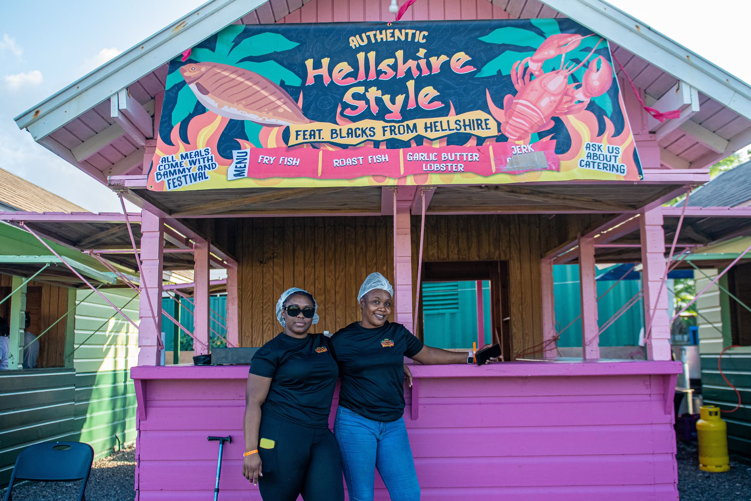 Two vendors at the Hellshire Style food hut in the festival village