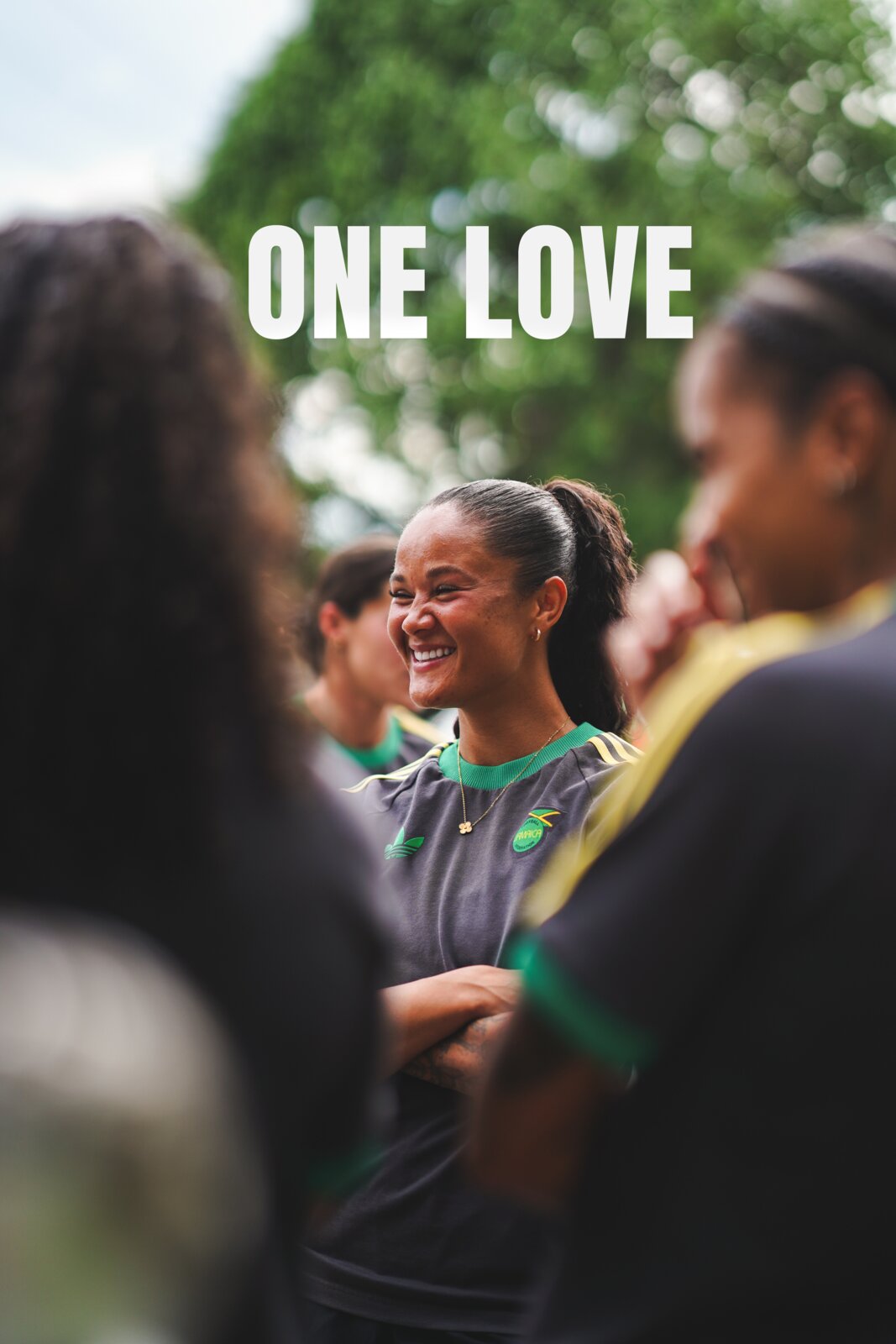 Reggae Girlz laugh together in a candid moment under One Love type