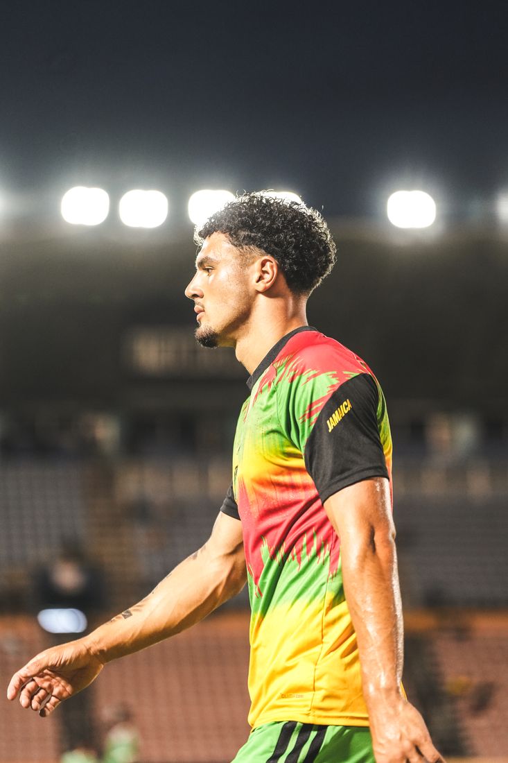 A player in the warm-up top under the stadium floodlights