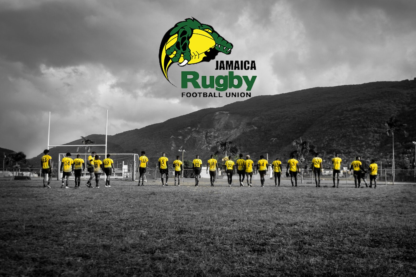 The Jamaica Rugby squad lines up behind the team banner in black and white