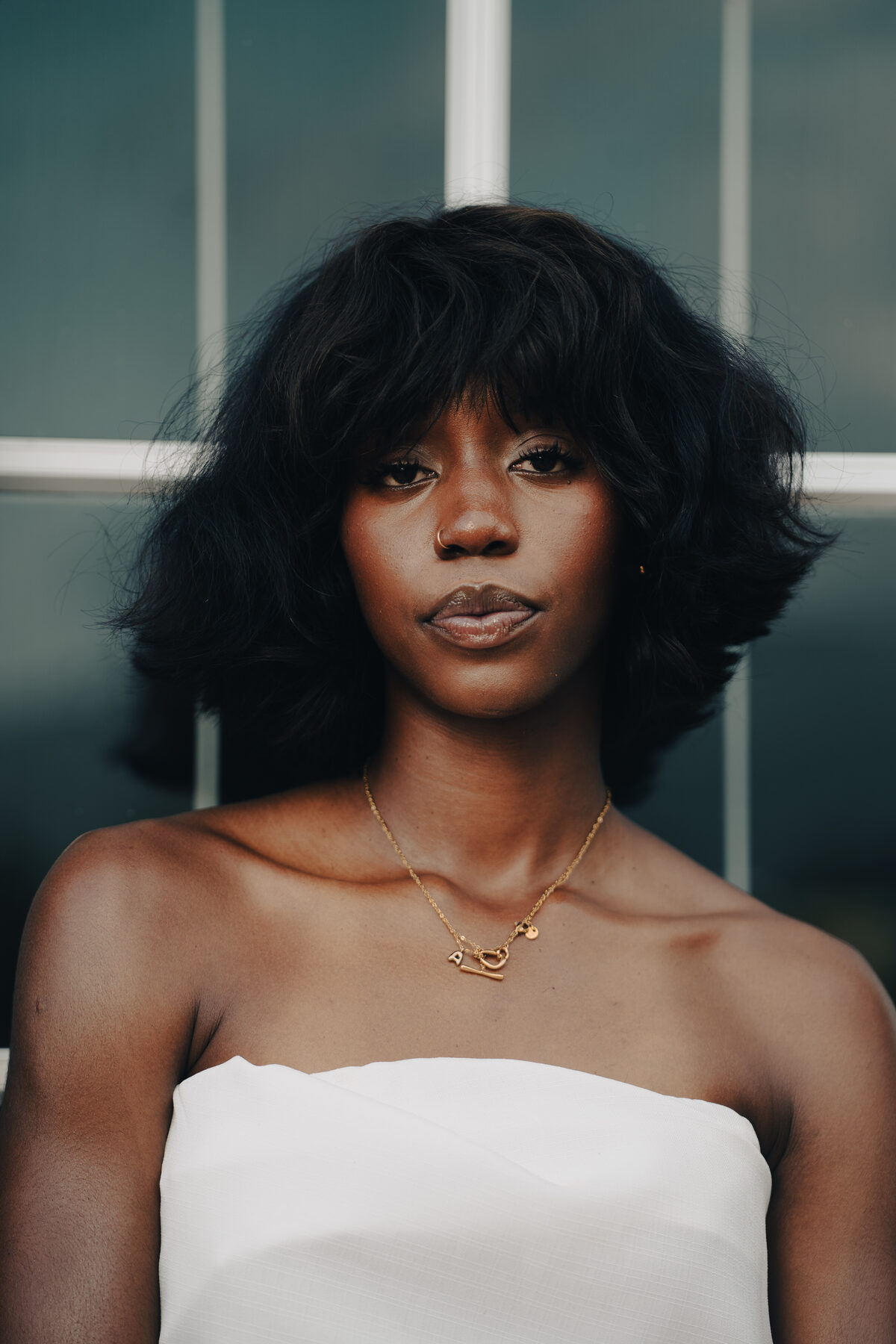 An editorial portrait of a woman by a window in soft light