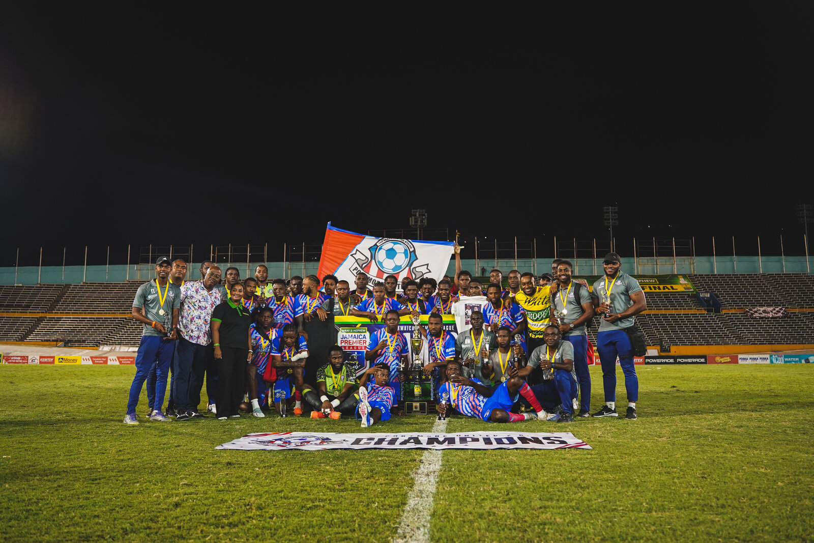 The championship team gathers behind the champions banner
