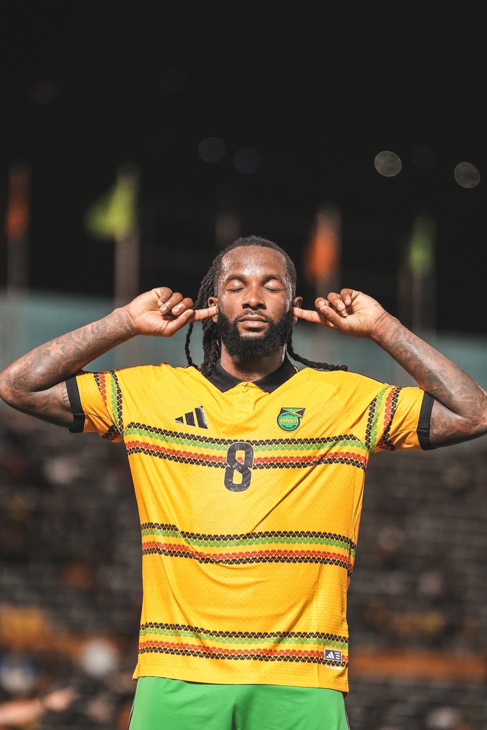 Jamaica's number 8 celebrates with his hands cupped to his ears