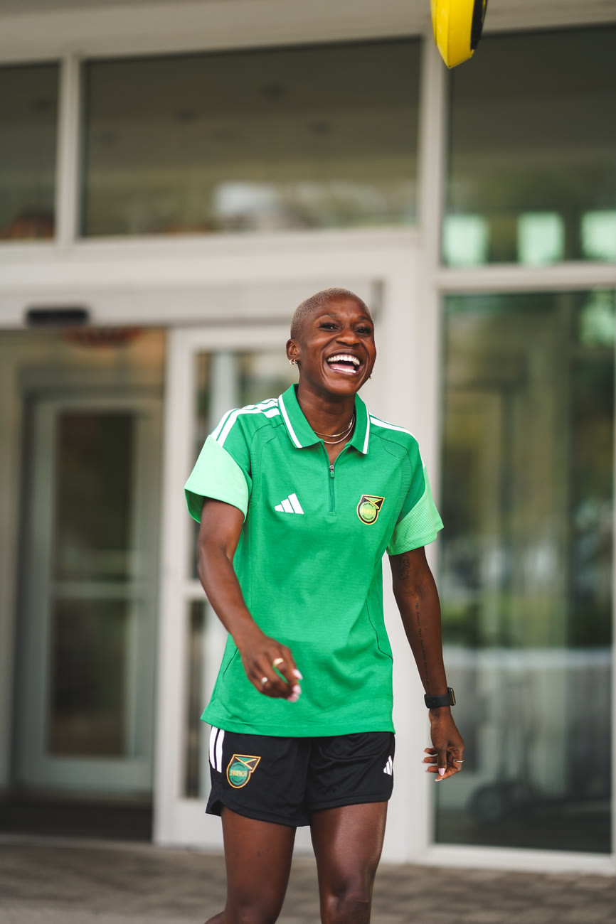 A smiling player leaves the team hotel in the green travel polo