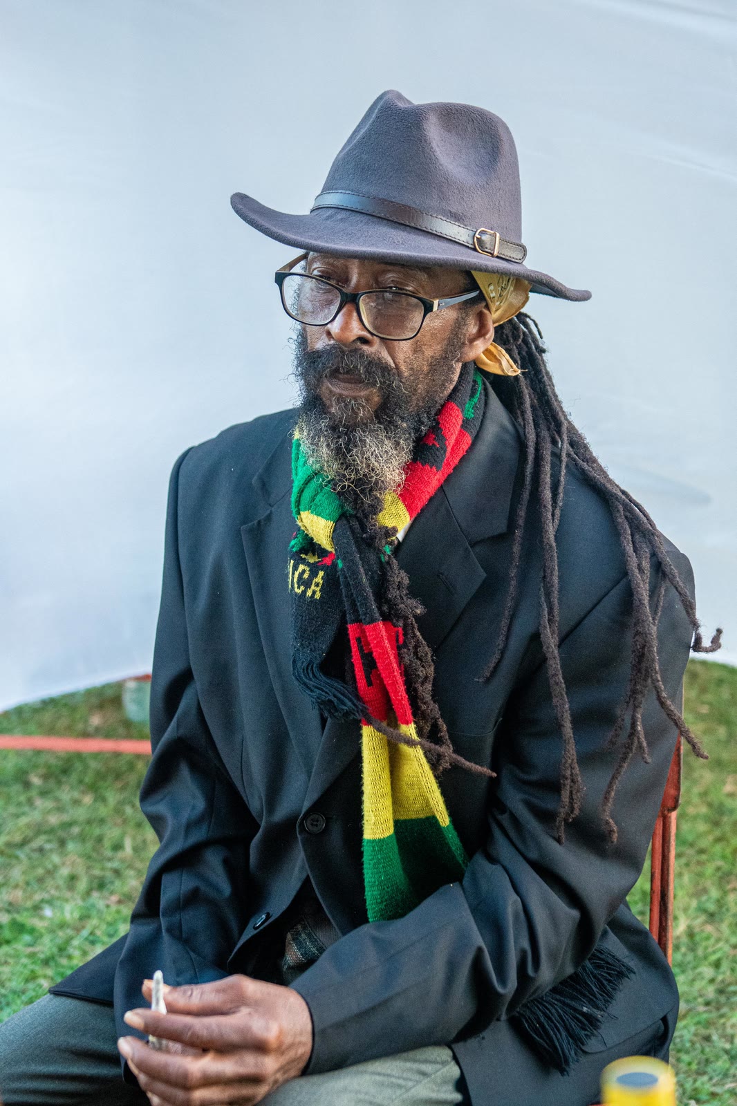 An elder in a hat and a red, gold and green scarf at Rebel Salute
