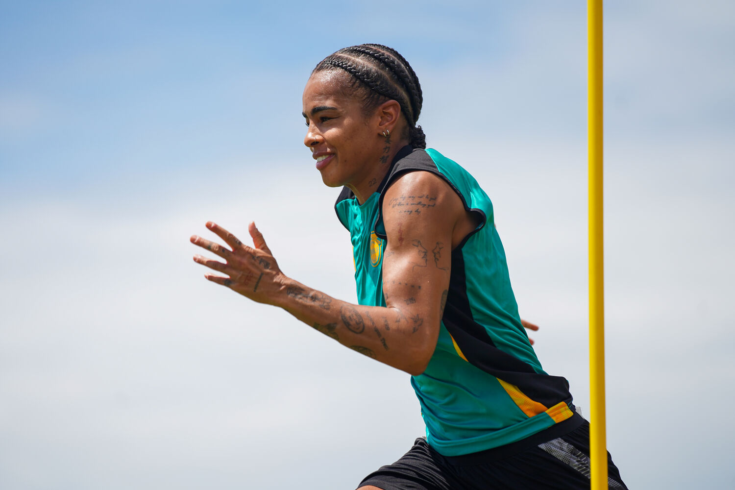 A track athlete mid-stride in national colours