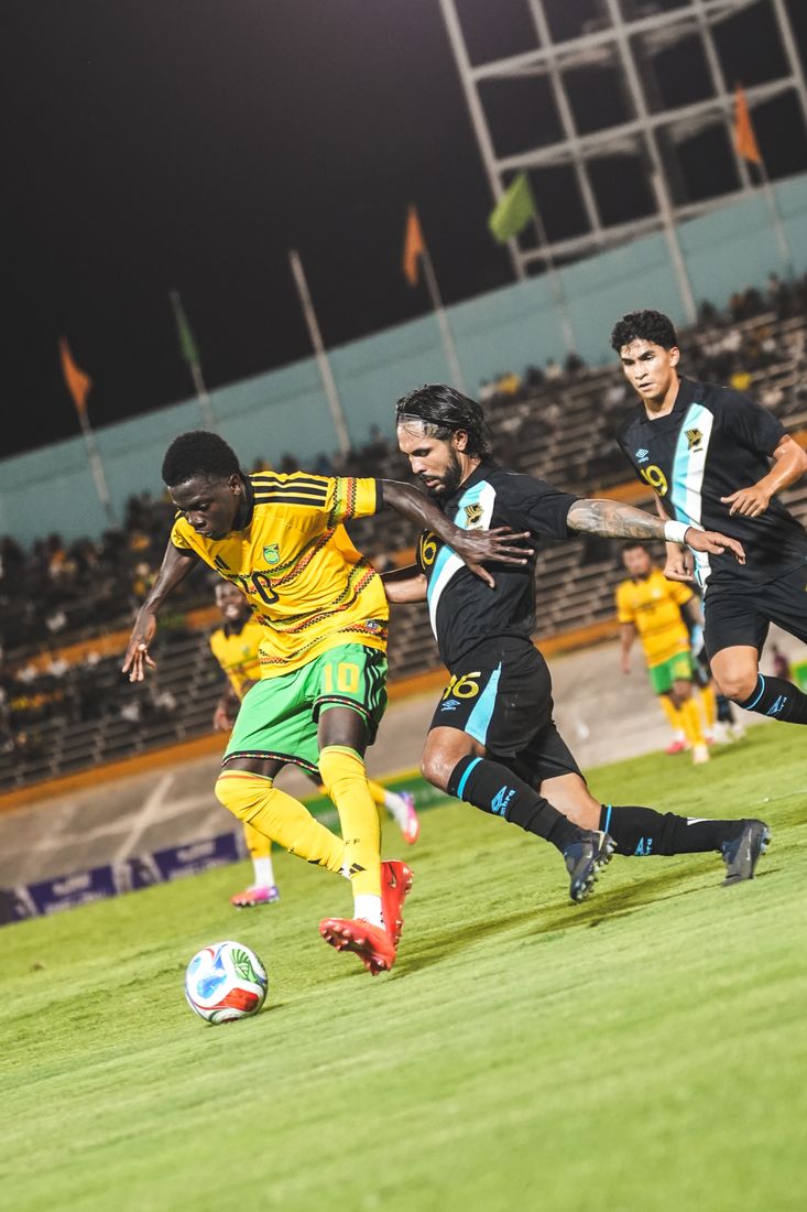 A Jamaica player shields the ball from a Guatemala defender
