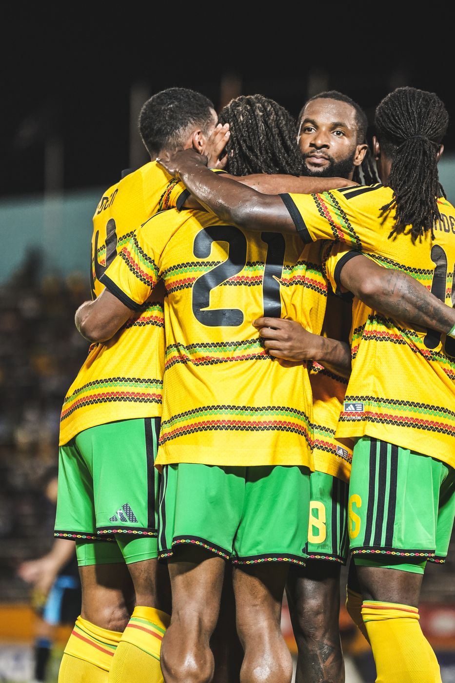 Reggae Boyz players hold each other in celebration