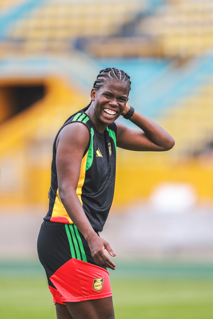 Bunny Shaw laughs with her hand in her hair at training