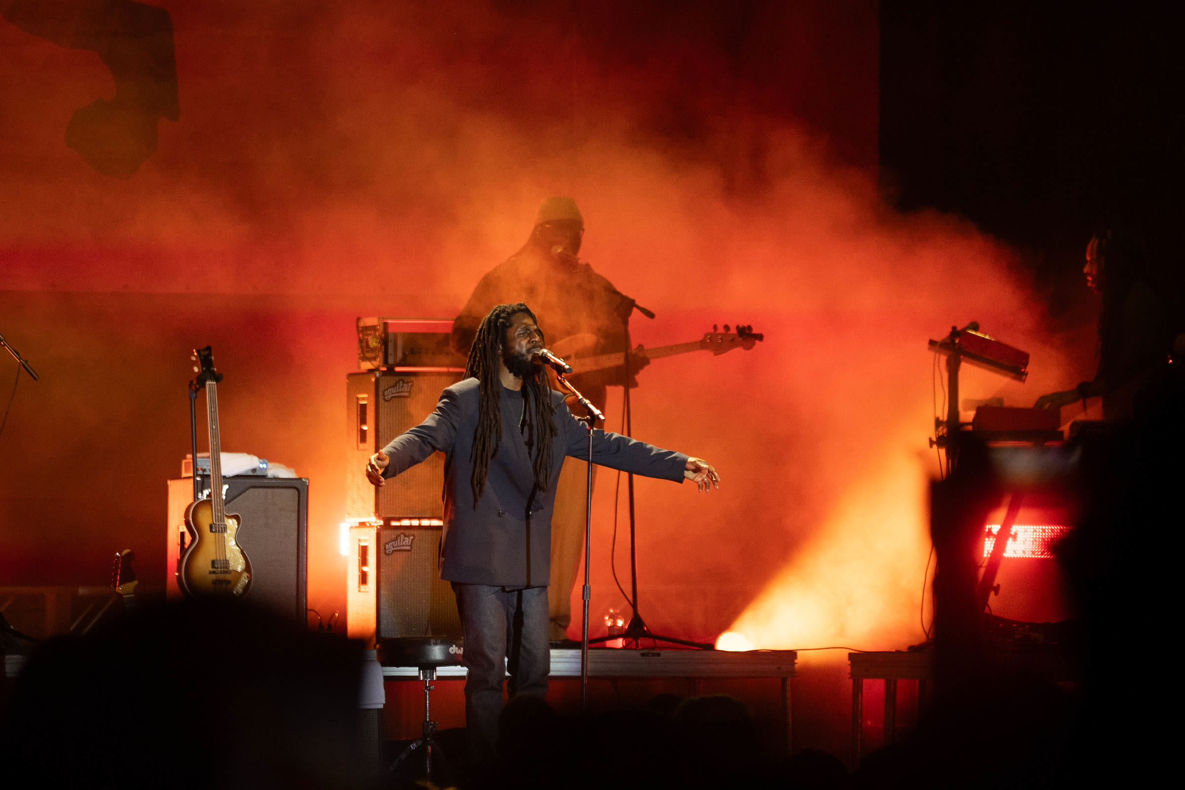 Chronixx opens his arms through orange stage smoke