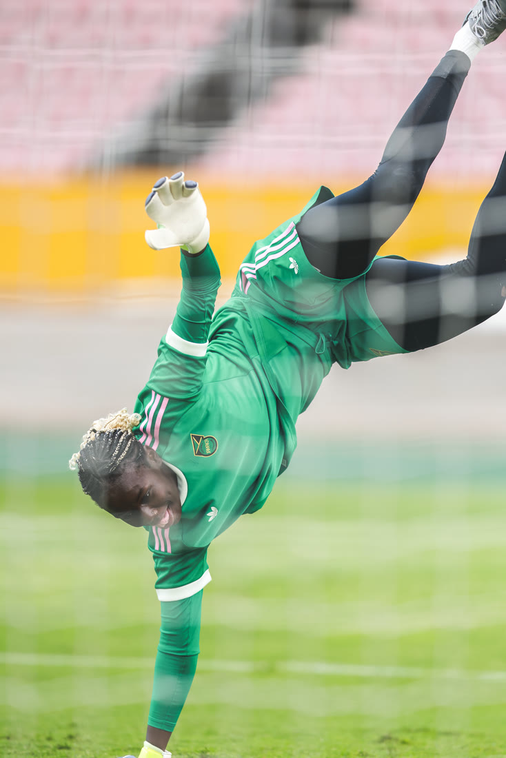The goalkeeper stretches upside down during training