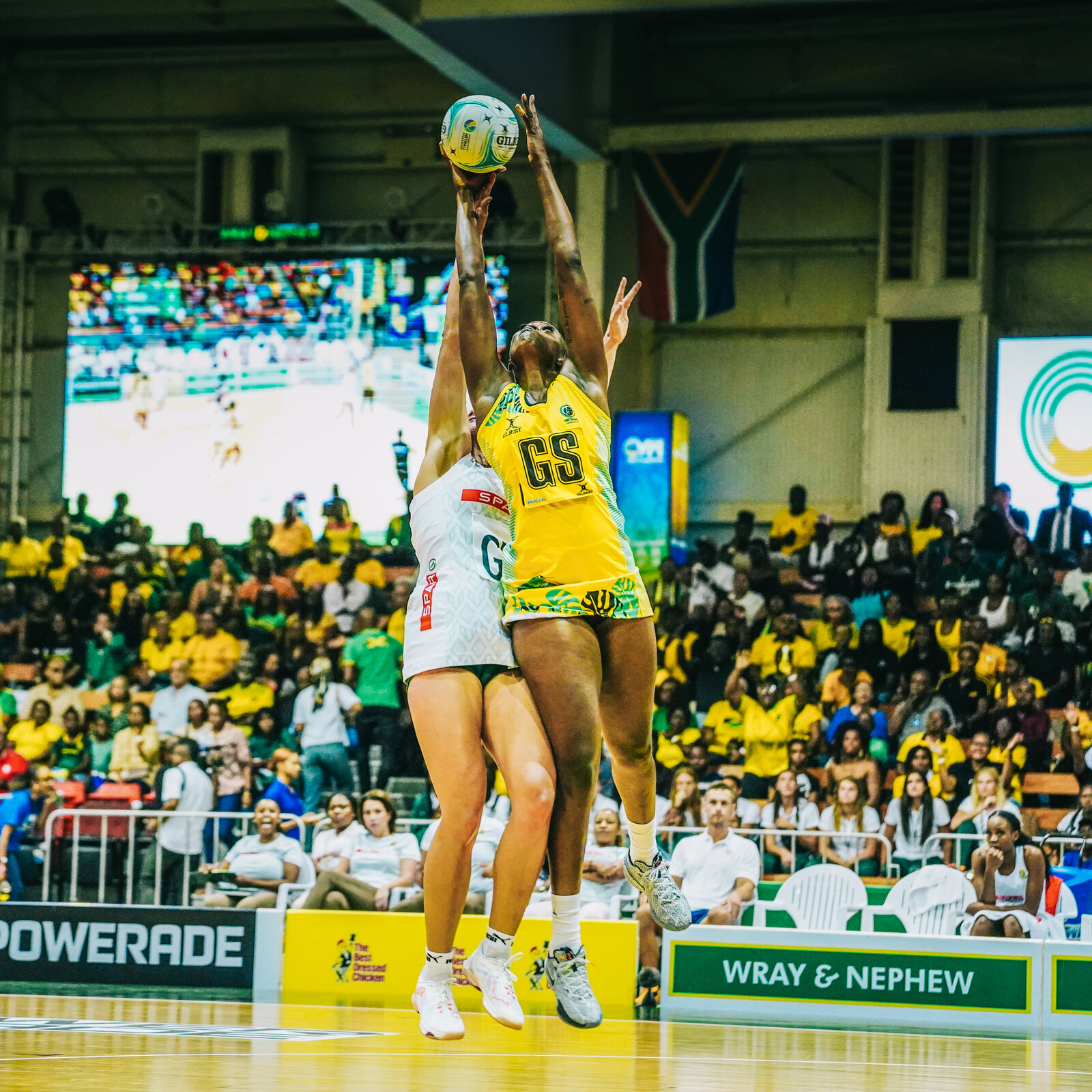 Two netballers rise for a high catch at the arena
