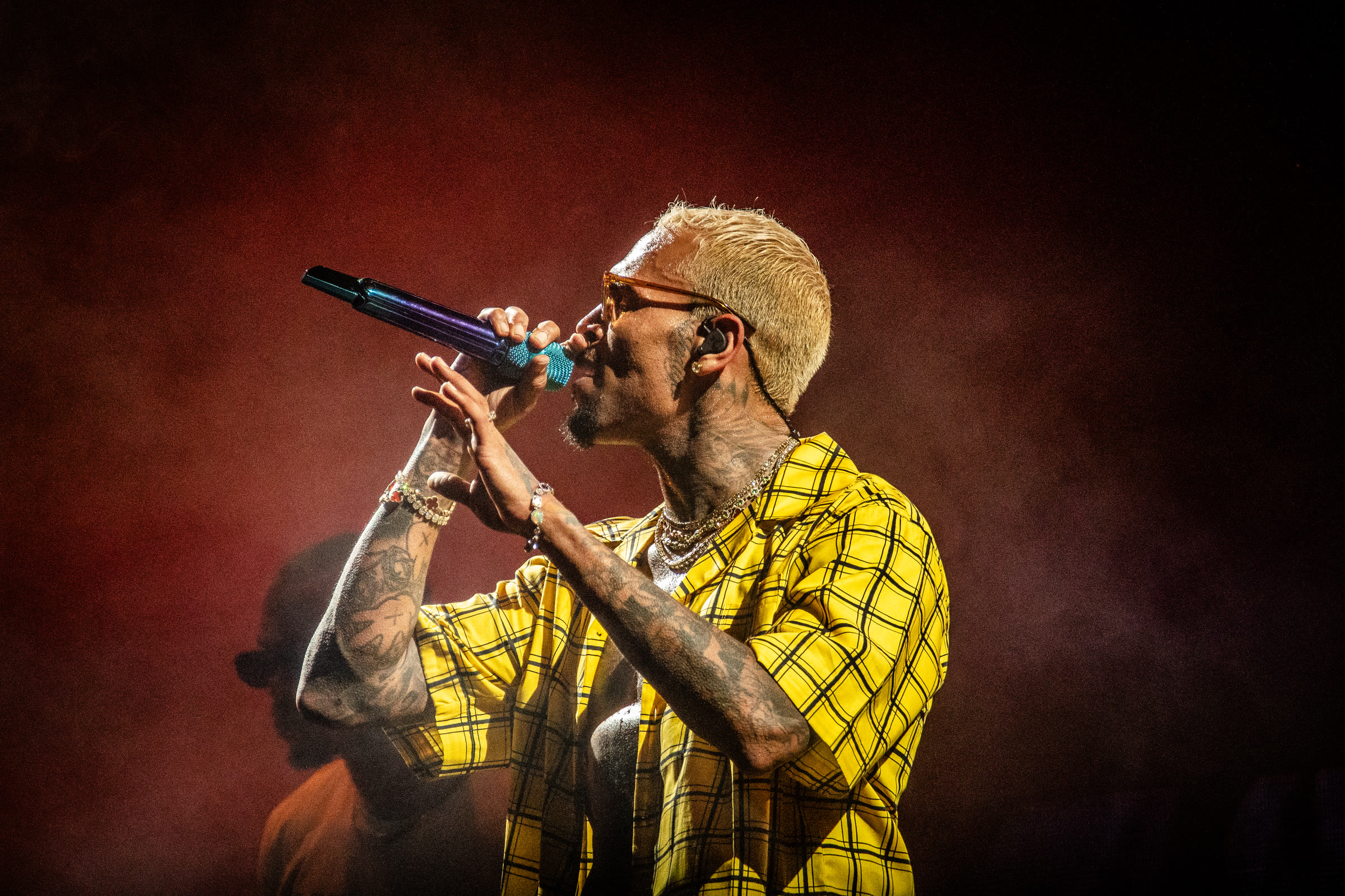 Breezy sings in a yellow plaid shirt