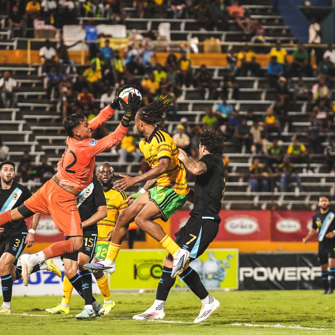The goalkeeper punches clear in a crowded penalty area