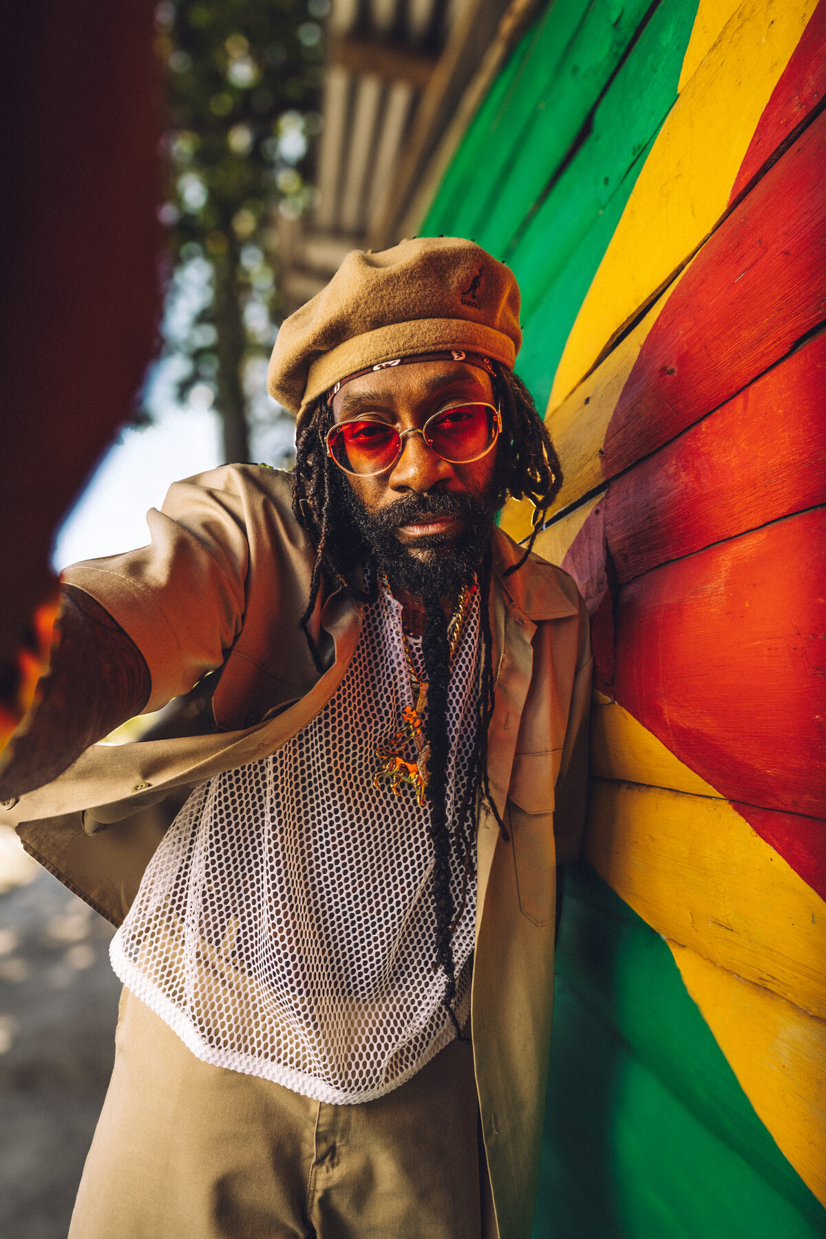 A man in Rasta-coloured print against Jamaican flag fabric