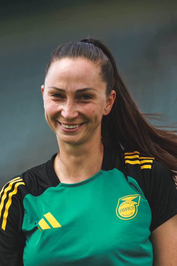 A smiling Reggae Girlz player in the teal training top